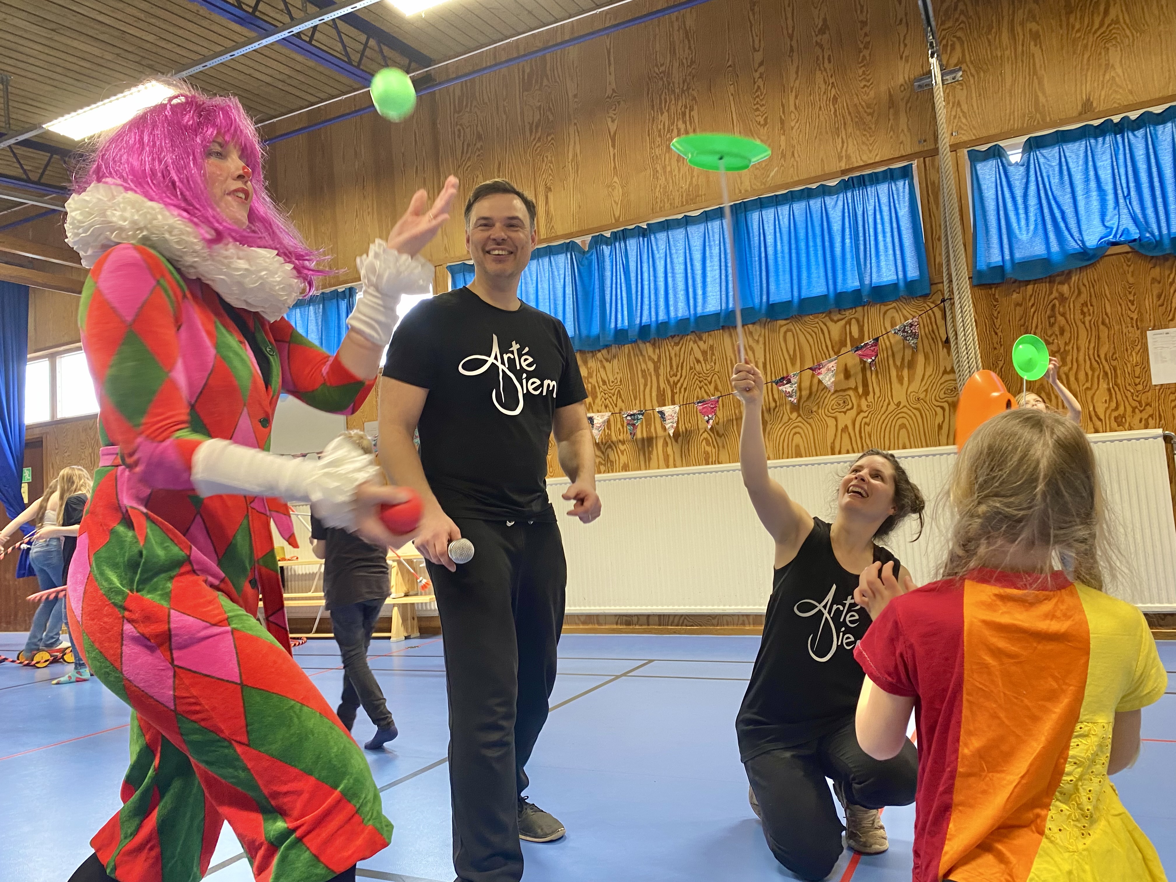 Cirkusartister gör cirkuskonster för elever i en skola.