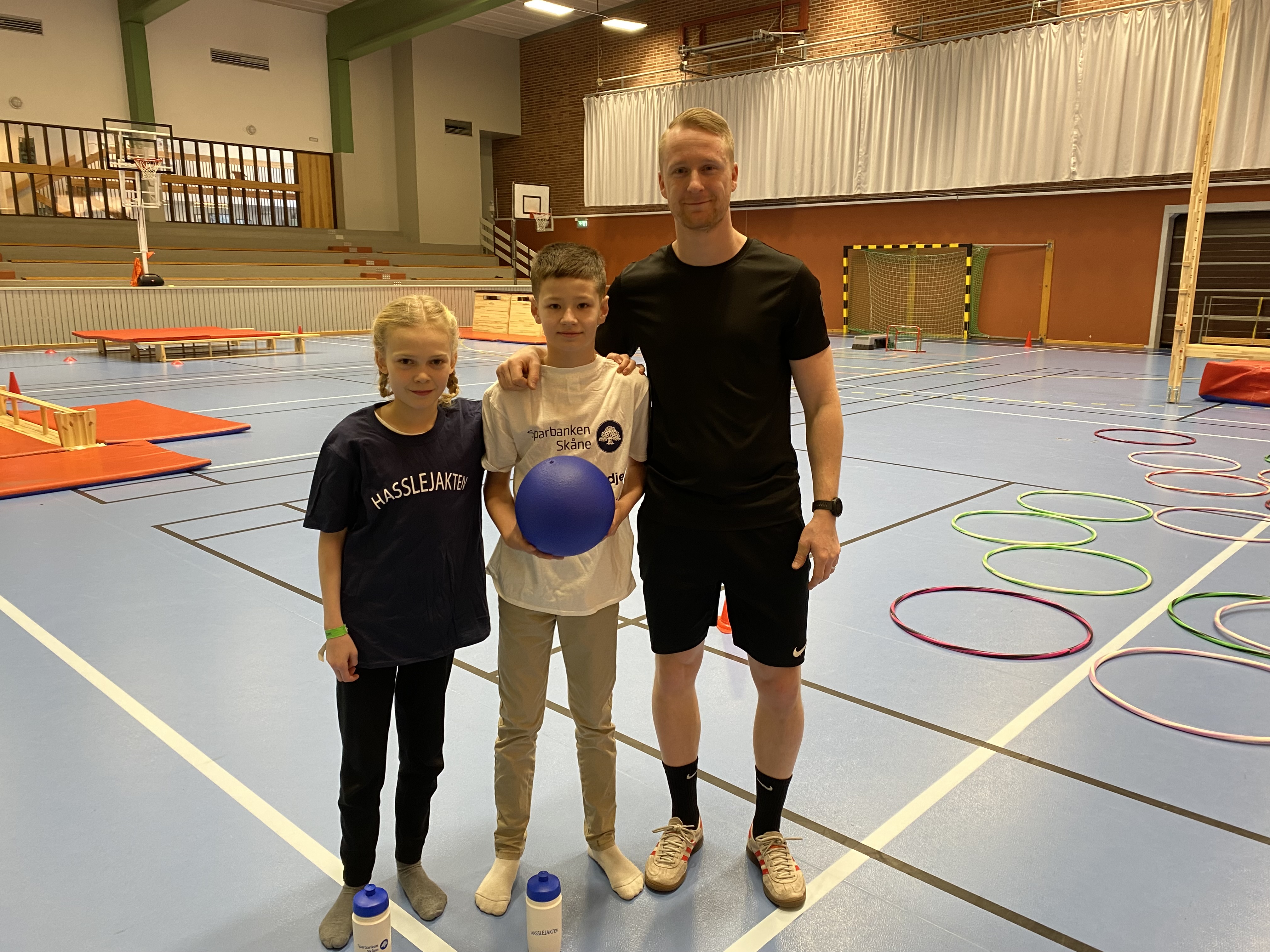 Elever med lärare i en gympahall.